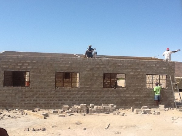 A roof is added to a new schoolhouse in Purros, Namibia